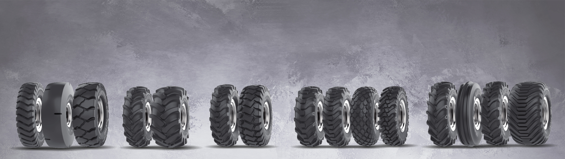 A row of off-highway tyres showcasing various tread patterns and sizes designed for rugged terrain and heavy-duty vehicles.