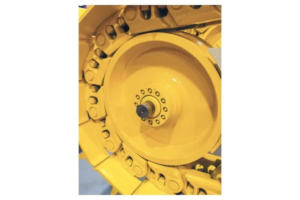 A detailed close-up of a yellow track link assembly, showcasing a large, central yellow wheel with visible bolts.